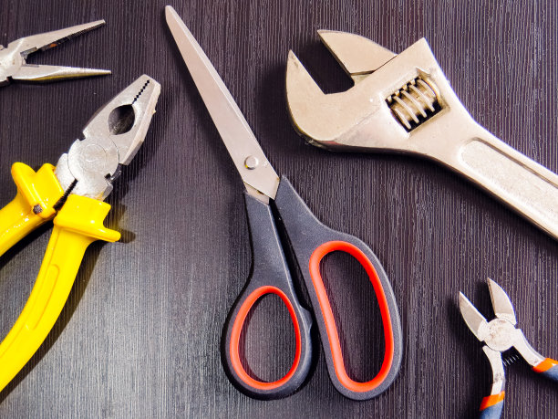 带木头背景的钳子、螺丝刀、剪刀和扳手图片下载