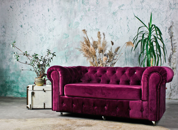 复古的紫色沙发靠在一堵质朴的墙上。乡村内部图片下载