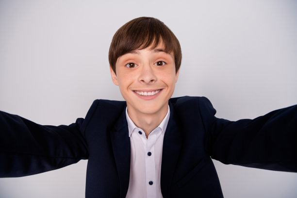 正面开朗的男孩的特写照片有乐趣的自由时间休息放松使照片博主视频电话活孤立穿现代服装夹克灰色背景图片下载