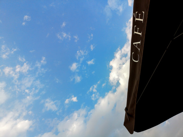 咖啡馆标志：黑色雨伞与蓝天白云图片下载