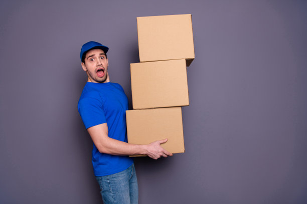 特写照片专业的专家，他，他，他的快递员，拿着有力的手，大的，大的，沉重的包裹盒子，扁平的移动，疲惫，紧张，穿着蓝色的t恤，帽子，牛仔裤，牛仔孤立的灰色背景图片下载