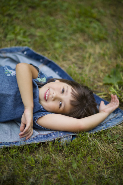 夏天，小女孩在草地上休息图片下载
