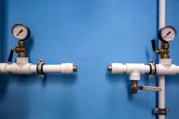 中心水管系统的压力计，在水管系统的塑料水管上有压力指示器，蓝色的墙是背景。Spase for your text。图片下载