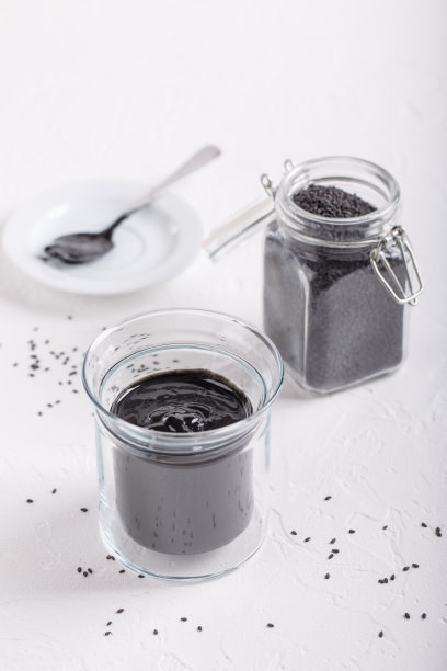 白底黑芝麻酱玻璃罐。由黑芝麻籽制成的天然糊状物。图片下载