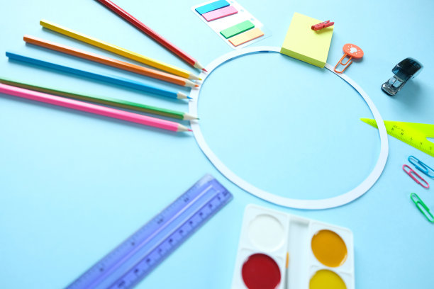 圆形框架与彩色铅笔剪刀在蓝色的背景，回到学校的概念图片下载