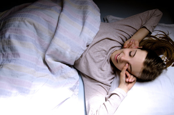 小女孩早上醒来后在她的床上伸展。图片下载