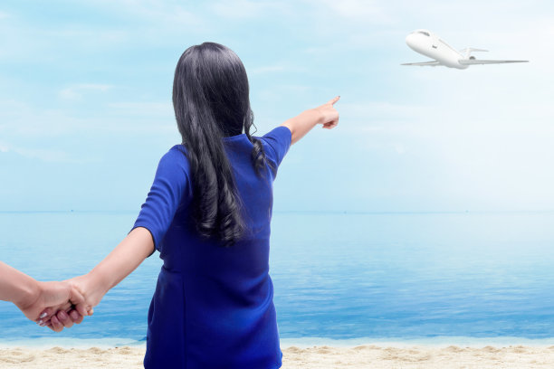 后视图亚洲女人牵着她的男朋友的手在海滩上图片下载