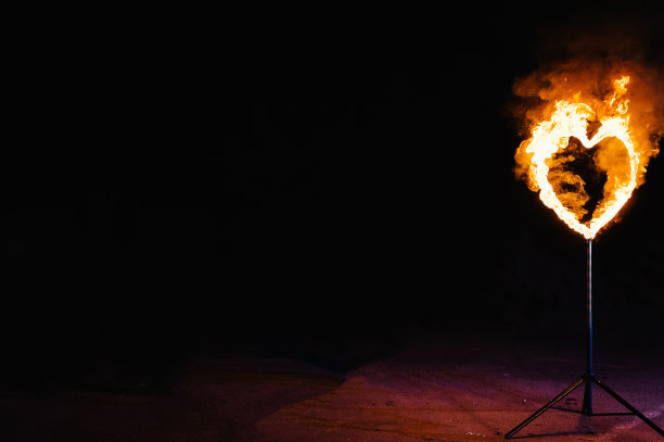 黑色背景上燃烧着手工制作的心。晚上有烟火表演。设计元素。文本的空闲空间。情人节快乐的明信片。结婚的概念。图片下载