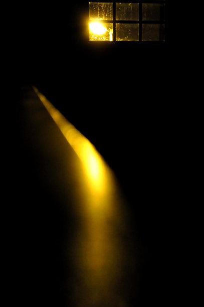 黑暗中透过窗户的黄色灯光图片下载