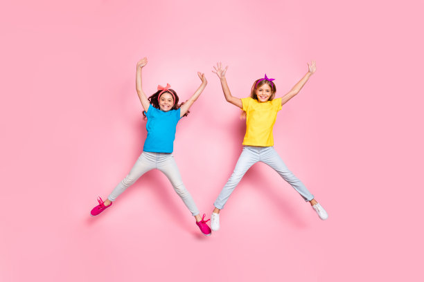 全尺寸照片的时尚，快乐的孩子移动举起双手，手臂，穿裤子，裤子孤立在粉红色的背景图片下载