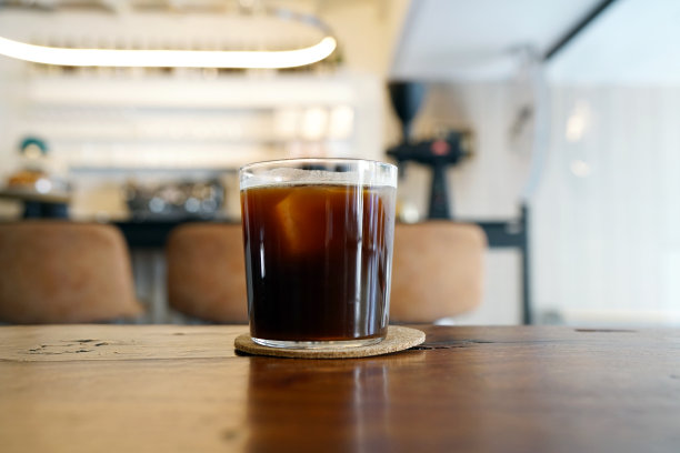 在桌子和复印空间上放一杯冰美式咖啡，这种咖啡的风格是用浓缩咖啡和水混合而成。图片下载