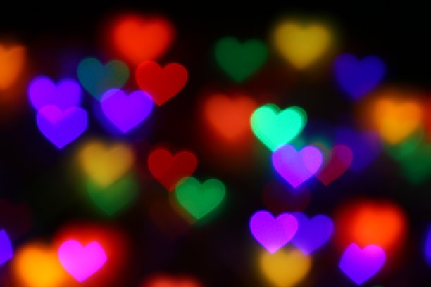 情人节彩色心形的散景黑色背景照明散景装饰在晚上的背景墙纸模糊情人，爱情图片的背景，照明心形的软夜抽象图片下载