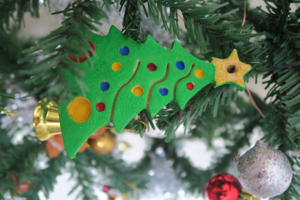 塑料人造圣诞树的形象，用自制的盐面团饼干切刀手绘装饰，像饼干一样烘烤，用丙烯酸或海报油漆手绘的金星圣诞树顶部，假圣诞树装饰的精灵灯图片下载
