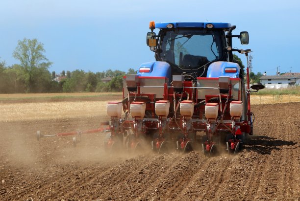 拖拉机与气动播种机在新犁的土地在夏季图片下载