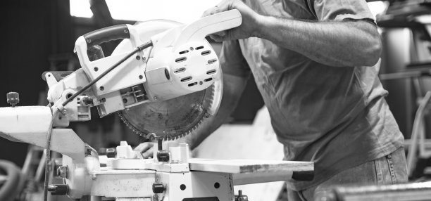 木匠用圆锯锯木板。木工车间中师傅的工作。黑白照片。图片下载