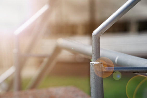 过马路的金属扶手，近景，阴影。太阳光束灯图片下载