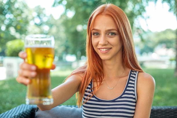 漂亮可爱的红发女人喝啤酒图片下载