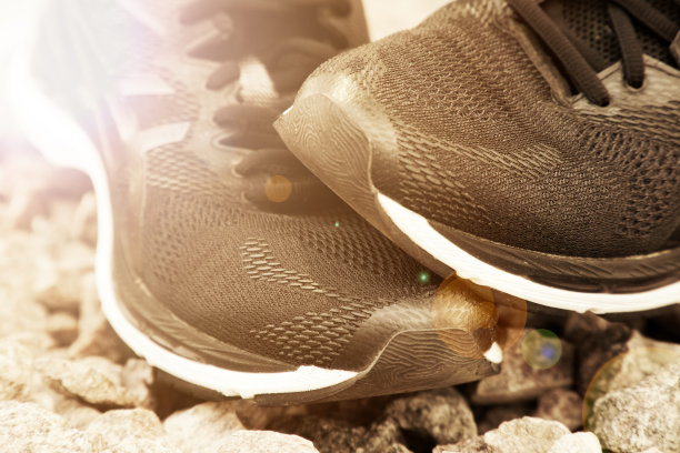 练习前穿跑鞋。公园里的跑步鞋，近距离的运动鞋。运动积极的户外生活理念。水平照片横幅为网站标题设计。太阳光束灯图片下载