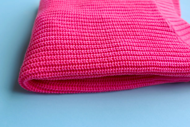 塑料粉红色夹克孤立在蓝色背景。图片下载