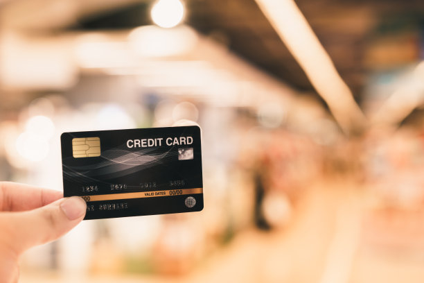 手握信用卡模糊超市，购物和零售的概念图片下载