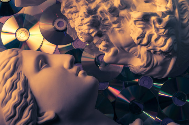 在闪闪发光的cd背景上，近距离地展示着男女头像的古董雕像。音乐的概念，风格，复古，爱。图片下载