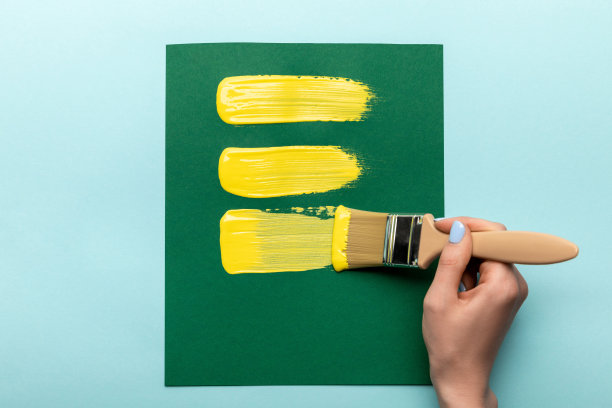 部分观点的女人拿着画笔和绘画在绿色的纸上的蓝色图片下载