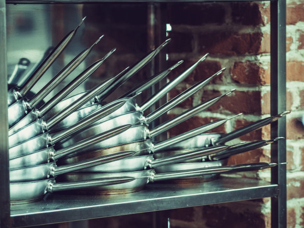 餐馆厨房里堆着的煎锅和炖锅。库存图片图片下载