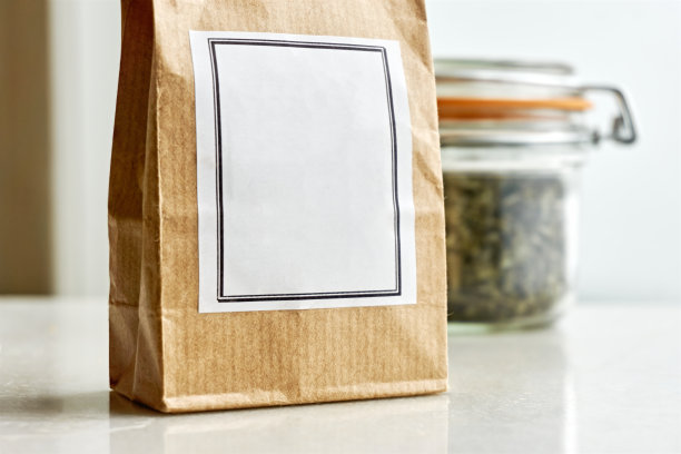 牛皮纸袋与空白标签前面的包玻璃罐与干香草或茶图片下载