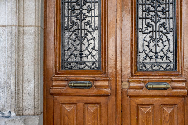 古董木门与框门板和古董华丽的金属格。法国巴黎古石建筑的仿古双门。经典建筑的对称性。图片下载