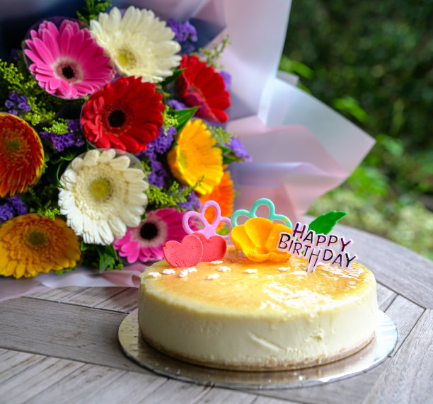 一束雏菊花和奶酪蛋糕作为生日礼物图片下载