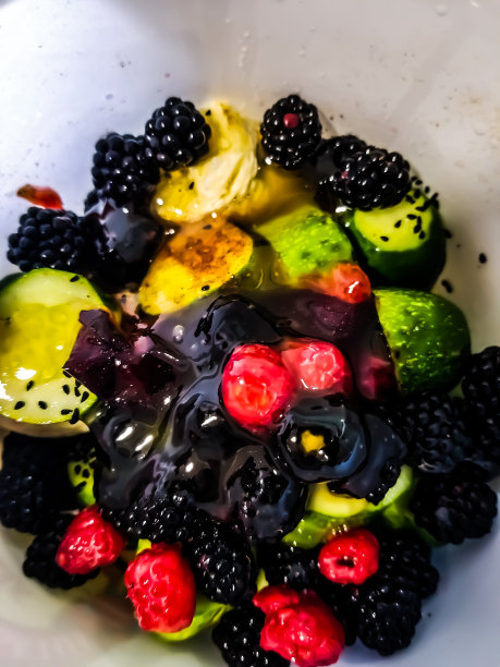 将浆果与树叶混合。各种新鲜浆果分离在白色背景。树莓，蓝莓，蔓越莓，黑莓和薄荷叶-股票形象图片下载