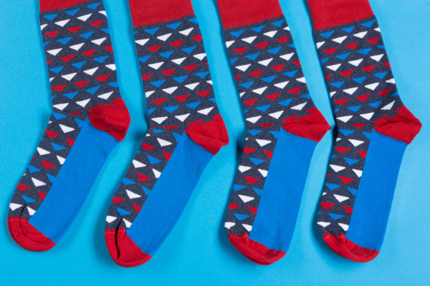 四种颜色的袜子躺在蓝色的背景上，两对，概念图片下载