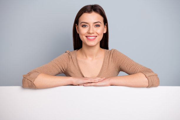 正面开朗可爱的女士特写照片手持横幅，空看放放文字孤立的银灰色背景图片下载