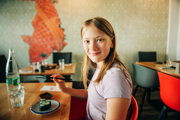 可爱的小女孩在亚洲餐厅吃寿司图片下载