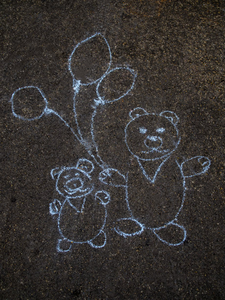 可爱的熊带着气球在柏油路上用蓝色粉笔画素描图片下载