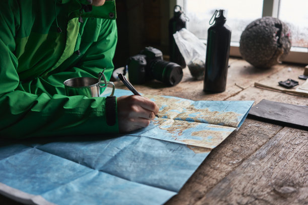 一个年轻的背包客正在挪威罗浮敦群岛的一个小木屋里计划他的旅行。图片下载