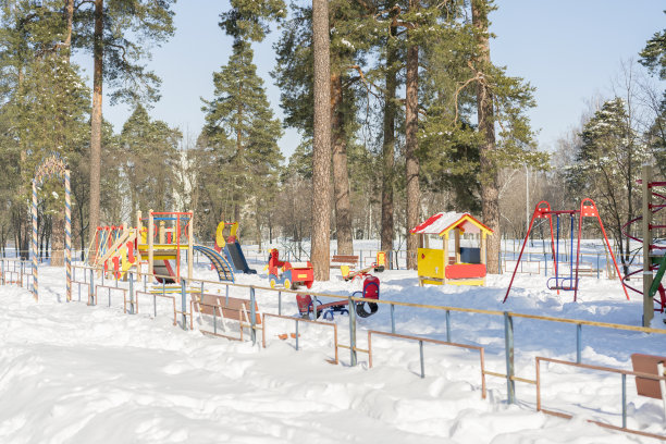冬季公园里的儿童游乐场。儿童游乐场在城市公园。阳光明媚的冬日。图片下载