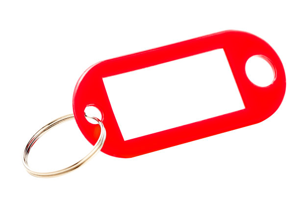红色键色小饰品与白色纸标签。孤立。图片下载