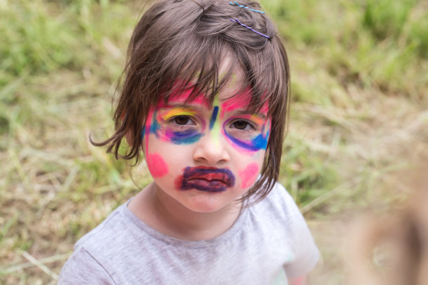 微笑的女孩用脸艺术画像老虎，小男孩做脸画，万圣节晚会，孩子用滑稽的脸画图片下载
