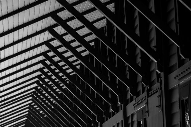 木制的固定遮阳篷和泰式建筑的墙壁沿着人行道的房子。黑色和白色的木质遮阳篷结构。木结构建筑外观设计。太阳控制结构的家。图片下载