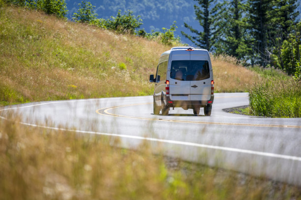 商业小型货车运行在蜿蜒的道路与山的两侧图片下载