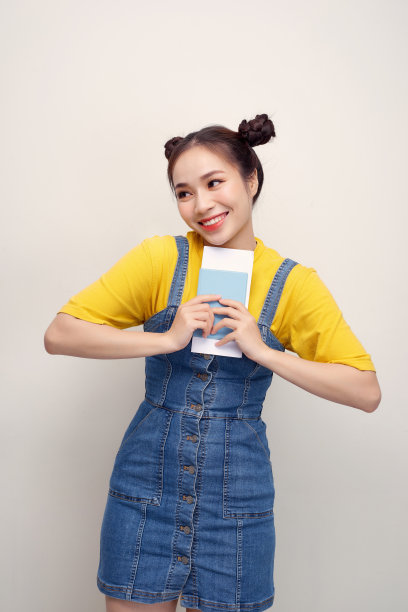 图片特写的快乐的非洲裔美国妇女看着相机，而持有护照和票孤立在白色的背景图片下载