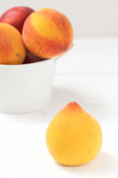 黄色的意大利桃在白色的木制背景上图片下载