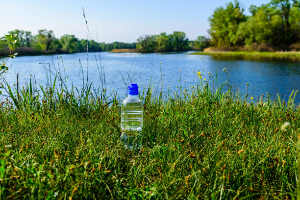塑料瓶和清水放在木桌上图片下载