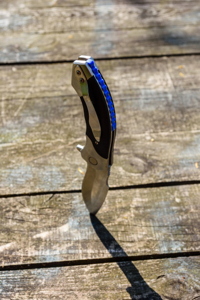 折叠刀卡在旧木板上图片下载