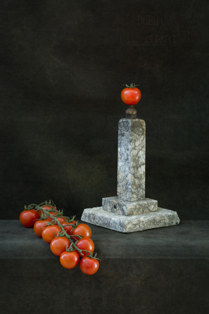 有樱桃番茄和花岗岩基座的静物“纪念碑”图片下载