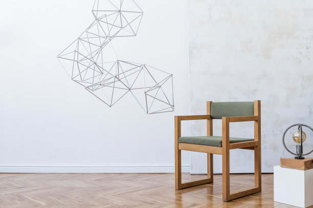 简约现代的室内开放空间，设计绿色扶手椅，三角形几何雕塑，时尚的灯和优雅的配件。白色墙壁上的抽象画。模板。图片下载