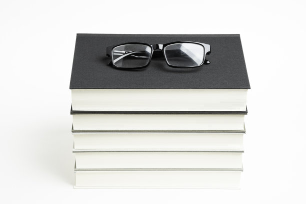 一套整齐堆放的五本书和老花镜图片下载
