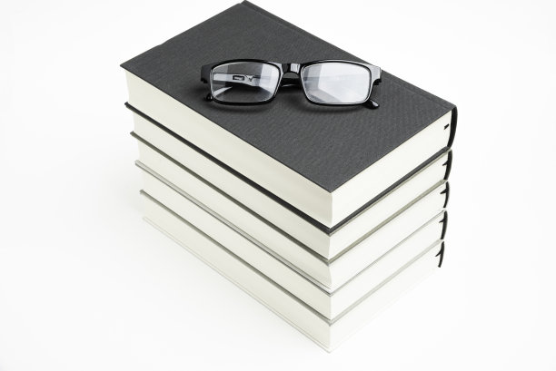 一套整齐堆放的五本书和老花镜图片下载