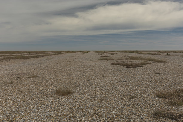 蓝天下开阔的卵石海滩图片下载